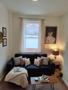 a living room with a blue couch and a window at John Street Apartments Flat 2 in Bristol