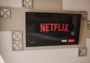 a television on a wall with the netflix sign on it at Hotel Ponta Verde Praia do Francês in Praia do Frances