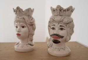 dos estatuas blancas con cabezas coronadas en una mesa en B&B Giulia, en Grammichele