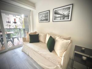 um sofá branco com duas almofadas verdes numa sala de estar em Exclusive Apartment in the Heart of Palermo Viejo PV1 by Apartments Bariloche em Buenos Aires