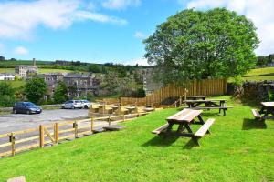 a group of picnic tables on the grass in a park at Robin Hood Inn in Hebden Bridge