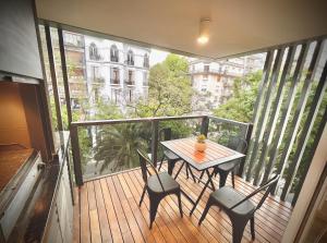 einen Holzbalkon mit einem Tisch und Stühlen darauf in der Unterkunft Exclusive Apartment in the Heart of Palermo Viejo PV1 by Apartments Bariloche in Buenos Aires