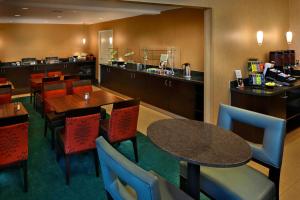 a restaurant with tables and chairs and a kitchen at Residence Inn Danbury in Danbury