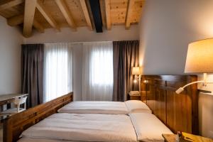 Agriturismo al Comarel في Tarzo: غرفة نوم بسريرين ونافذة