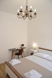 a bedroom with a bed and a table and a chandelier at Caporama in Terrasini