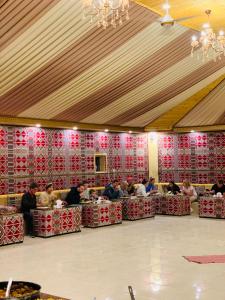 un groupe de personnes assises à des tables dans une pièce dans l'établissement sand magic camp, à Wadi Rum