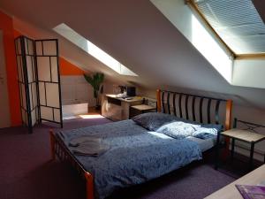 een slaapkamer met een bed, een bureau en een raam bij Penzion Vulture Ostrava in Ostrava