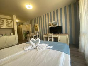 um quarto com uma cama com 2 cisnes brancos em PANORAMA BAY 20 Fancy Studio em Sveti Vlas