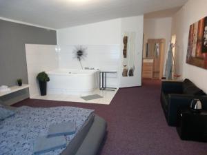 Penzion Vulture Ostrava في أوسترافا: غرفة معيشة مع حوض استحمام وأريكة