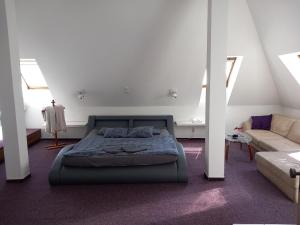 オストラヴァにあるPenzion Vulture Ostravaのベッドルーム(ベッド1台、ソファ付)