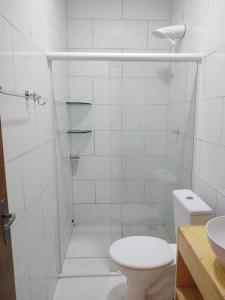 a bathroom with a shower with a toilet and a sink at Tambazulik pousada in Maragogi
