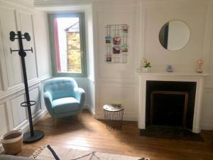 un salon avec une chaise bleue et une cheminée dans l'établissement LE GARENGEOT - WIFi - CENTRE VILLE - PROPERTY RENTAL NM, à Vitré