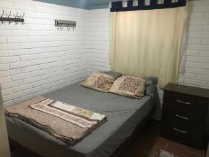 ein Bett mit zwei Kissen darauf in einem Schlafzimmer in der Unterkunft Casa full amoblada: 3 dormitorios + estacionamiento in Coquimbo