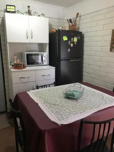 eine Küche mit einem Tisch und einem schwarzen Kühlschrank in der Unterkunft Casa full amoblada: 3 dormitorios + estacionamiento in Coquimbo