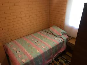 ein kleines Zimmer mit einem Bett mit einer Decke darauf in der Unterkunft Casa full amoblada: 3 dormitorios + estacionamiento in Coquimbo