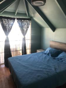 ein Schlafzimmer mit einem blauen Bett und einem Fenster in der Unterkunft Casa full amoblada: 3 dormitorios + estacionamiento in Coquimbo
