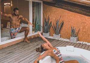 a man and a woman laying in a bath tub at Hotel Ponta Verde Praia do Francês in Praia do Frances