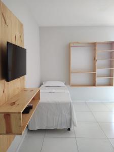 a bedroom with a bed and a tv on a wall at Tambazulik pousada in Maragogi