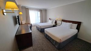 Habitación de hotel con 2 camas y TV en Hotel Diego de Almagro Iquique en Iquique