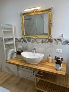 bagno con lavandino bianco e specchio di Caporama a Terrasini