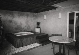 a room with a bath tub and a table at Hotel Ponta Verde Praia do Francês in Praia do Frances