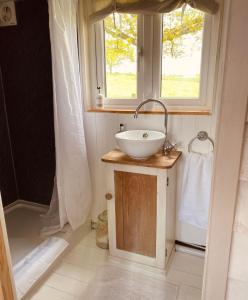 ein Bad mit einem Waschbecken und einem Fenster in der Unterkunft Hideaway in the Hills in Church Stretton