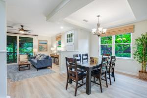 a dining room and living room with a table and chairs at Nihilani at Princeville 19C in Princeville