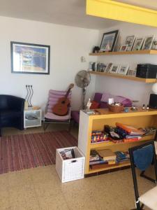 a living room with a table and a chair and a guitar at Apartamentos Clipper Llafranc Costa Brava in Llafranc