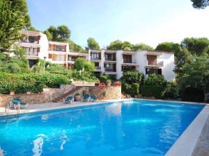 a swimming pool in front of a building at Apartamentos Clipper Llafranc Costa Brava in Llafranc