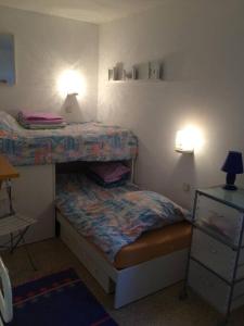 a small bedroom with two bunk beds and a lamp at Apartamentos Clipper Llafranc Costa Brava in Llafranc