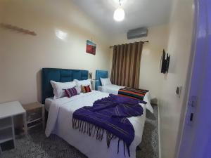 Hotel Mentaga في تارودانت: غرفة نوم بسريرين مع لوحات ارشادية زرقاء