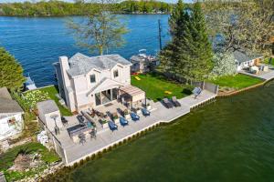 an aerial view of a large house on the water at Sunrise Sunset Island Lake House with Pontoon! in Fenton