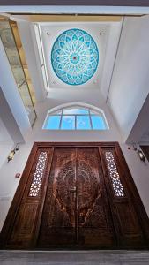 a large wooden door with a stained glass window on it at Hotel Bankir Khiva in Khiva