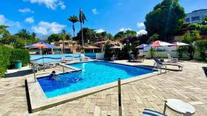 einen Pool mit Stühlen und Sonnenschirmen in einem Resort in der Unterkunft Yacht Village 106 Praia - NBI - Ponta Negra in Natal