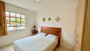 Schlafzimmer mit einem Bett mit weißer Bettwäsche und einem Fenster in der Unterkunft Yacht Village 106 Praia - NBI - Ponta Negra in Natal