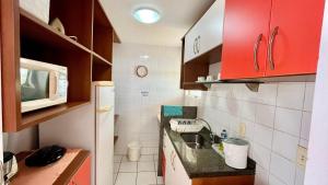 a small kitchen with a sink and a microwave at Yacht Village 106 Praia - NBI - Ponta Negra in Natal