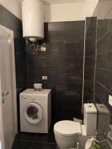 een badkamer met een wasmachine en een toilet bij Dakiba Apartment in Vlorë