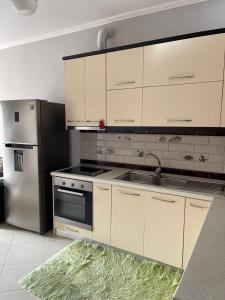 een keuken met witte kasten en een roestvrijstalen koelkast bij Dakiba Apartment in Vlorë
