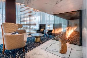 a lobby with a fireplace and a chair and a table at Residence Inn by Marriott Jersey City in Jersey City