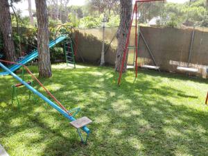 un parque infantil con un tobogán en un patio en Chalet con piscina Rana verde en Chiclana de la Frontera