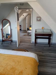 1 dormitorio con cama, mesa y espejo en la maison des taillis en Saint-Paul