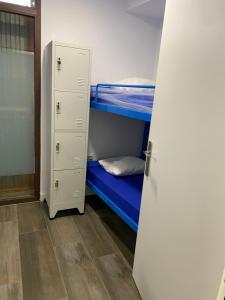 a room with two bunk beds and a closet at Vagabond Vieiras Beds & Dinner Albergue in La Portela de Valcarce