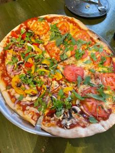 a pizza sitting on top of a pan on a table at Vagabond Vieiras Beds & Dinner Albergue in La Portela de Valcarce