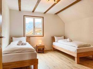a bedroom with two beds and a window at Alpine Chalet in Kandersteg