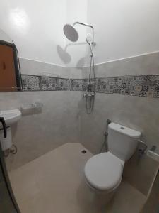 La salle de bains est pourvue de toilettes et d'une lumière sur le mur. dans l'établissement Hotel Mentaga, à Taroudant