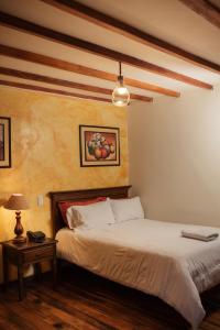 a bedroom with a bed and a table with a lamp at Hotel Spa Mansion Santa Isabella in Riobamba