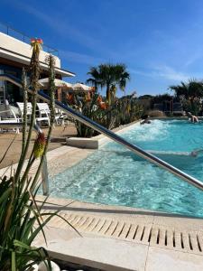 a swimming pool with people in a resort at Mobile home grand confort 3 chambres neuf in Saint-Raphaël