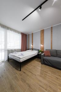 1 dormitorio grande con 1 cama y 1 sofá en Нові затишні smart-квартири LеГо, en Uzhhorod