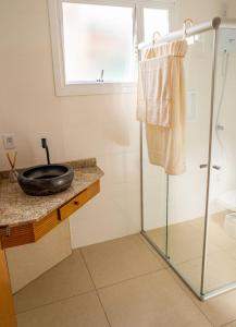 a bathroom with a glass shower and a sink at Casa di legno italiana in Bento Gonçalves