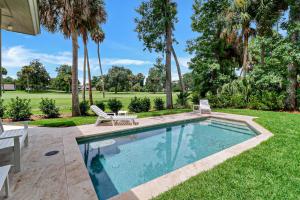 a swimming pool in a yard with palm trees at 7 Ginger Beer - Fairway Breeze in Hilton Head Island